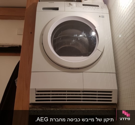 מייבש כביסה לבן מותקן על מדף עץ